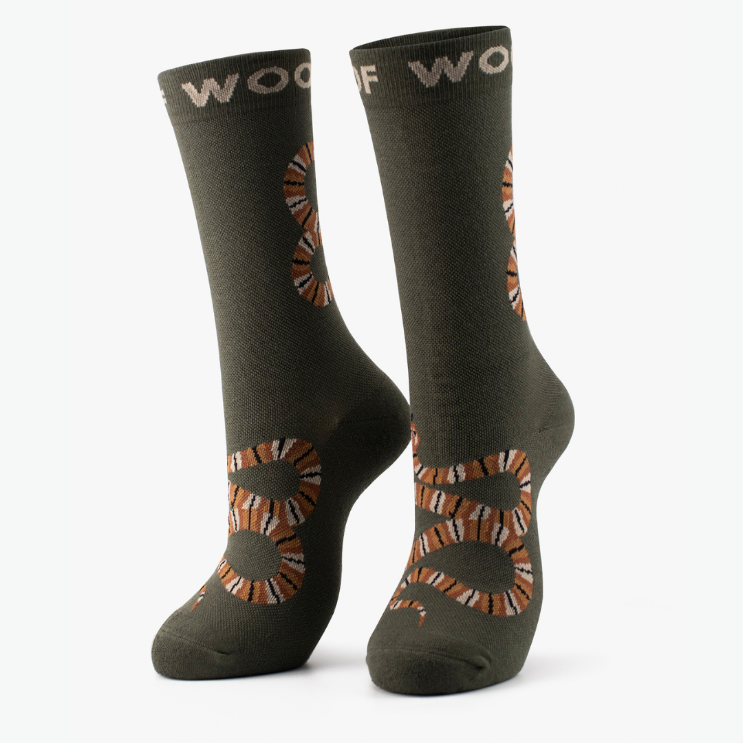 Pair of olive green Bamboo Crew Compression Socks with snake design standing against a plain white background.